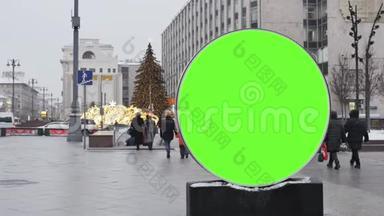 一个大的圆形广告牌，有一个绿色的屏幕，安装在街道上，用来装饰新年。
